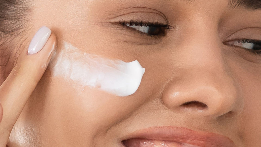 Woman applying moisturiser to her face